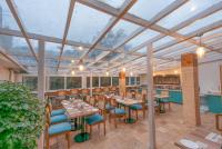 Un comedor con mesas y sillas de madera. en Excel Hotels & Resorts Mall Road Nainital, en Nainital