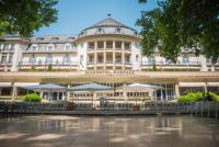 a large building with umbrellas in front of it at Parkhotel Kurhaus in Bad Kreuznach