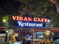 Un cartel de un restaurante cafetería Vran por la noche. en Magia Hotel - Spa & Wellness, en Avcılar