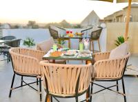 开罗Amon Pyramids View Inn的庭院里配有桌椅和食物