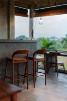 dos sillas y una mesa frente a un bar en Joni Ubud Hostel, en Ubud
