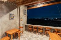 un restaurante con mesas y sillas de madera y una ventana en Joni Ubud Hostel, en Ubud