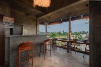 Un restaurante con un bar con sillas y vistas. en Joni Ubud Hostel, en Ubud