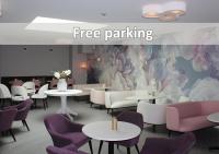 Un restaurante con mesas y sillas moradas y un mural. en Best Western Valhall Park Hotell, en Ängelholm