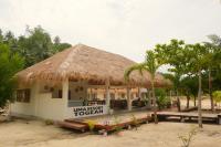 un ristorante sulla spiaggia con tetto di paglia di Uma Resort Togean a Katupa