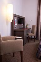 a hotel room with a couch and a desk with a television at IntercityHotel Bonn in Bonn