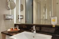 a bathroom with a sink and a shower and a mirror at IntercityHotel Bonn in Bonn