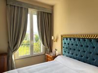 un dormitorio con una cama y una ventana en Sarzana Park Hotel, en Sarzana