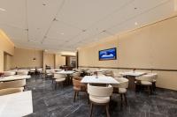 um restaurante com mesas e cadeiras em uma sala em Atour Hotel Beijing Guomao Dongdaqiao Subway Station em Pequim