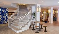 a staircase in a lobby with a table and stools at Delamar 4*Sup-Adults only (18+) in Lloret de Mar