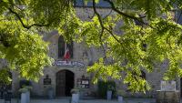 ein Steingebäude mit einer Flagge davor in der Unterkunft L'Hostellerie du Château de Bricquebec in Bricquebec