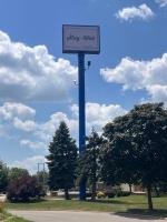 un cartel en un poste azul en un parque en Stay-Well Inn - Monroe, en Monroe