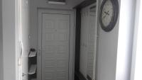 eine Uhr an einer Wand neben einer weißen Tür in der Unterkunft House Prljevic in Užice