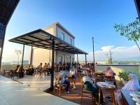 un grupo de personas sentadas en mesas en una cubierta en Front One Hotel Gombong, en Gombong