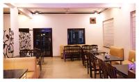 Un restaurante con mesas y sillas en una sala. en Hotel Temptation Ultimate Prayagraj AC NR NON AC Both Room, en Prayagraj