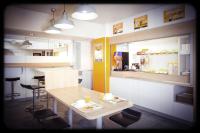 cocina con mesa, sillas y barra en Unisotel Saintes Ex F1, en Saintes