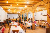 a group of people sitting at tables in a restaurant at Sólyom Major - Gut Falkenhof in Şoimuşu Mic