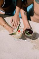 Eine Frau hält einen Drink in einem Glas Wein. in der Unterkunft Hotel Beso de Sal Resort in Colán