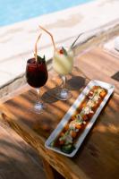 Drei Cocktails und ein Tablett mit Speisen auf einem Tisch in der Unterkunft Hotel Beso de Sal Resort in Colán