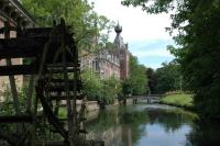 a river in a city with a bridge and buildings at Lavan in Leuven