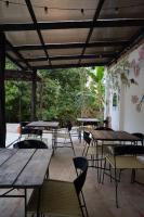 een lege patio met houten tafels en stoelen bij Hotel Boutique Albania in Otanche