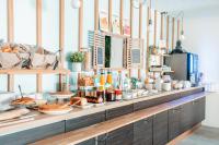 Una línea de buffet con pan y comida en ella. en Brit Hotel Confort Saint-Lô, en Saint Lo