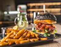 een bord met een hamburger en frietjes op een tafel bij Golden Moon Apartment in Bratislava