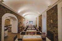 Una larga fila de mesas en una habitación con una pared en Hospedería Convento de la Parra, en La Parra