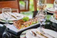 uma mesa com um prato de comida e copos de vinho em Green Turtle Highland Resort em Dauin