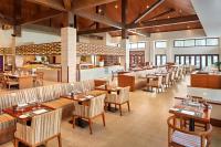 een restaurant met tafels en stoelen en een bar bij Pullman Danang Beach Resort in Da Nang