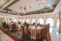 uma sala de banquetes com mesas e cadeiras e um tecto em Taj Lake Palace Udaipur em Udaipur