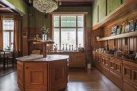 a large kitchen with wooden cabinets and a large island at Skogsbrynet B&B, Bredsjö Nya Herrgård in Hällefors