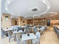 une salle à manger avec des tables et des chaises blanches dans l'établissement Theessence hotel chanthaburi, 