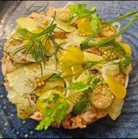 a pizza with vegetables on a blue plate at Altes Pfarrhaus Hotel und Restaurant in Bad Überkingen