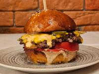 Una hamburguesa con queso y pimientos en un plato en La Opt Apartments, en Oradea