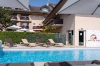 Una piscina con tumbonas al lado de un edificio. en Logis Hotel Arc En Ciel, en Thonon-les-Bains