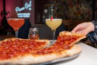 two slices of pizza on a table with two drinks at Hotel Ziggy On Sunset in Los Angeles