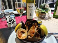 Un plato de ostras y una botella de vino en Hotel Posada Las Lengas, en Veintiocho de Noviembre