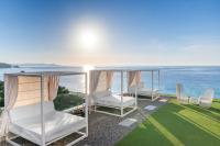 Dos sillas blancas en un patio con vista al océano. en Hotel Planamar by Escampa Hotels, en Platja d&#39;Aro