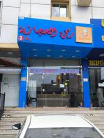 un negozio di fronte a un edificio con scritte rosse di Qasr Aljoud Serviced Apartments a Abha