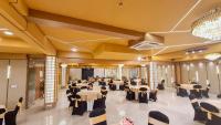 a banquet hall with tables and chairs in a room at Hotel Golf View Sakura & Suites in Gurgaon