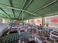 a restaurant with tables and chairs and a green ceiling at Ramma TheHotel - 200 mtrs from Nakki Lake in Mount Ābu