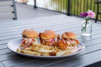 Un plato con dos sándwiches de pollo y papas fritas en The LOOM Hotel, Tapestry Collection by Hilton, en Warwick