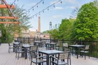 una fila de mesas y sillas en un patio en The LOOM Hotel, Tapestry Collection by Hilton, en Warwick