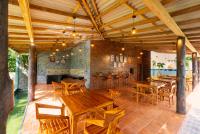 uma sala de jantar com mesas e cadeiras de madeira em The Eight em Hikkaduwa