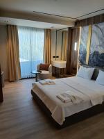 Una habitación de hotel con una cama grande y una silla. en Golden Stone Hotel Akçay, en Edremit