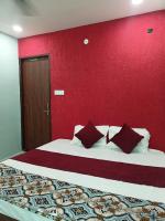 a bedroom with a large bed with a red wall at Hotel Shri Ji in Bhopal