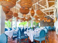 Un restaurante con mesas blancas, sillas azules y candelabros. en THE SEANDYOU Resort, en San Juan