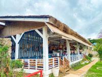 Un edificio con techo de paja con muchas botellas. en THE SEANDYOU Resort, en San Juan