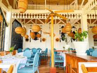 Un restaurante con sillas y mesas azules y lámparas. en THE SEANDYOU Resort, en San Juan